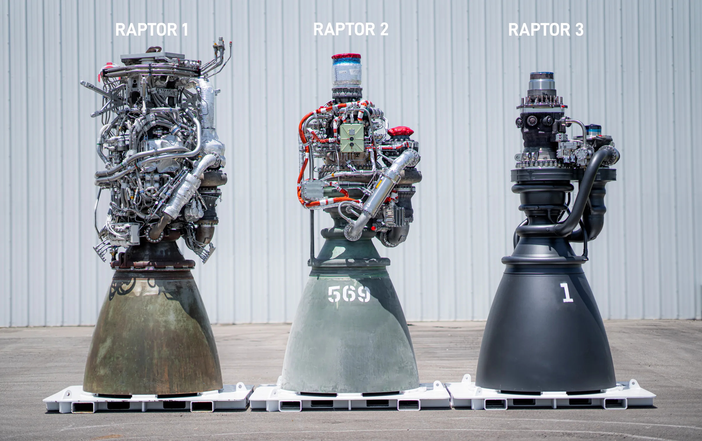 Raptor 1, 2 and 3 rocket engines standing side by side, each one visibly simpler than the last.